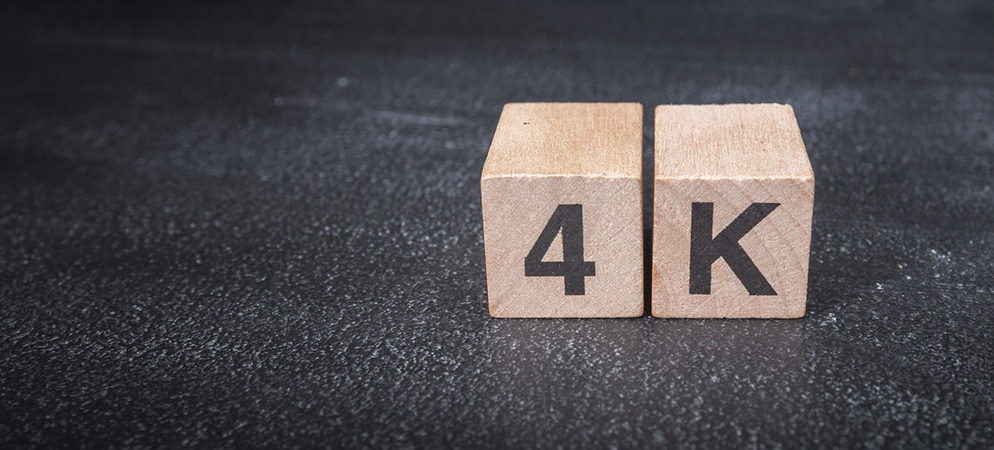 Wooden blocks spelling 4K on dark background, ultra HD video resolution concept for display technology, streaming and AV systems.