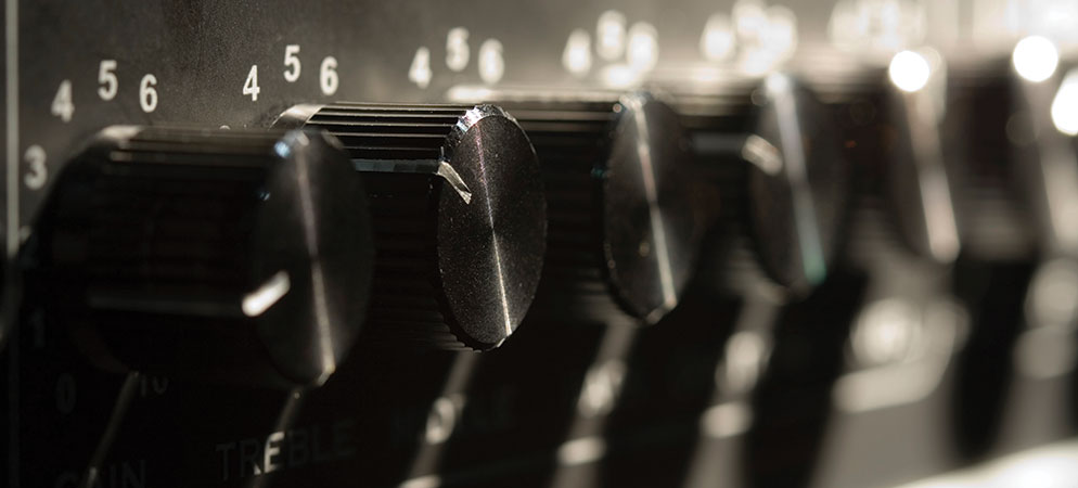 Close-up of audio mixer equalizer knobs and level controls for sound engineering, recording studio, and live event audio setup