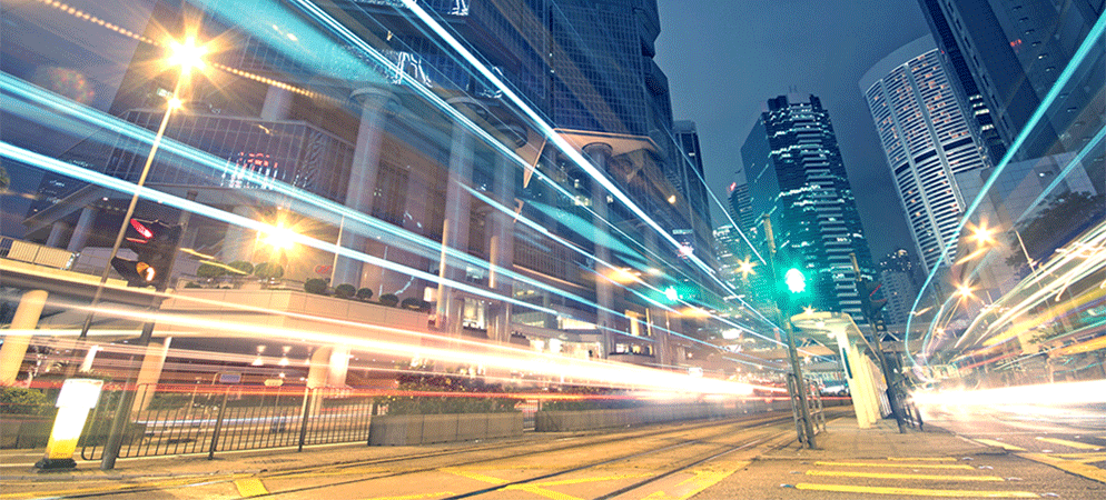 Night city street with light trails and skyscrapers, urban traffic motion blur and modern downtown skyline at dusk