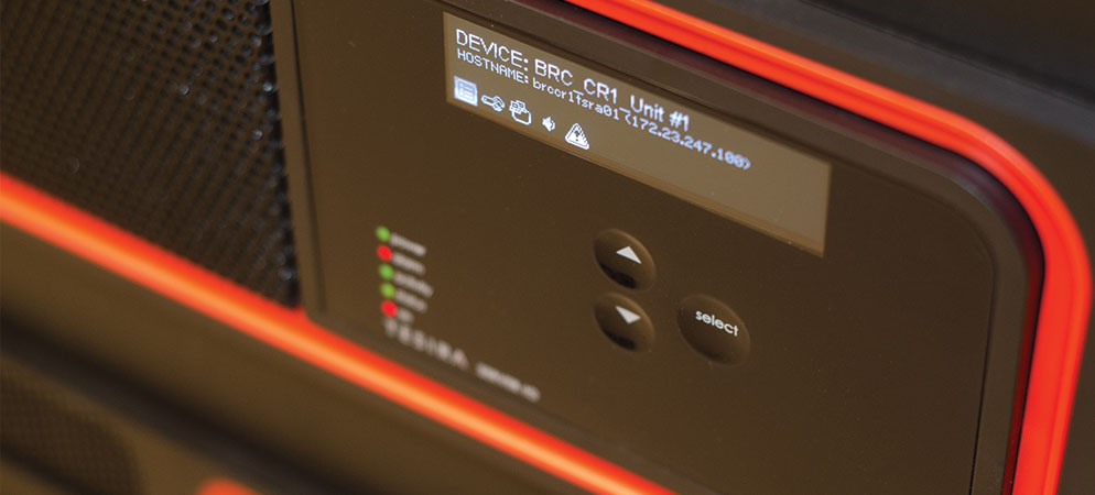 Close-up of Biamp rack-mounted AV device control panel with LCD status display and indicator lights for conference audio system setup