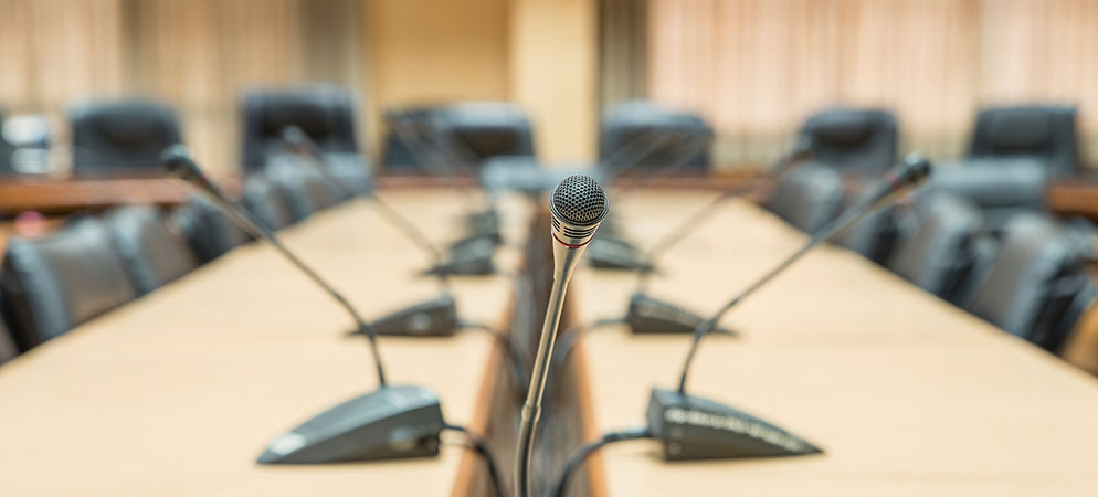 Conference room table with gooseneck microphones for board meeting audio, corporate meeting room communication setup