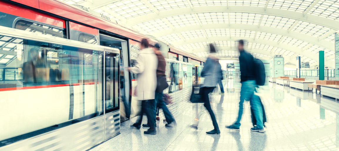 Blurred commuters boarding modern subway train in bright transit station with glass platform doors, conveying fast-paced urban travel scene