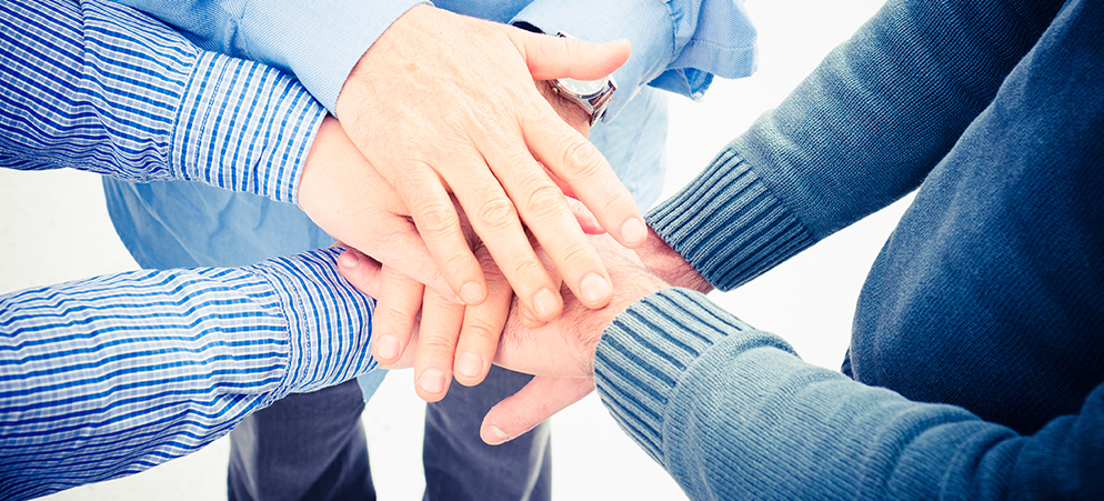 Teamwork concept with coworkers stacking hands together, collaboration and unity gesture in business group setting