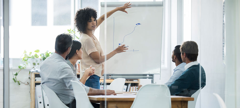 Business presentation in conference room with speaker at flip chart, team meeting and workplace training session in modern office