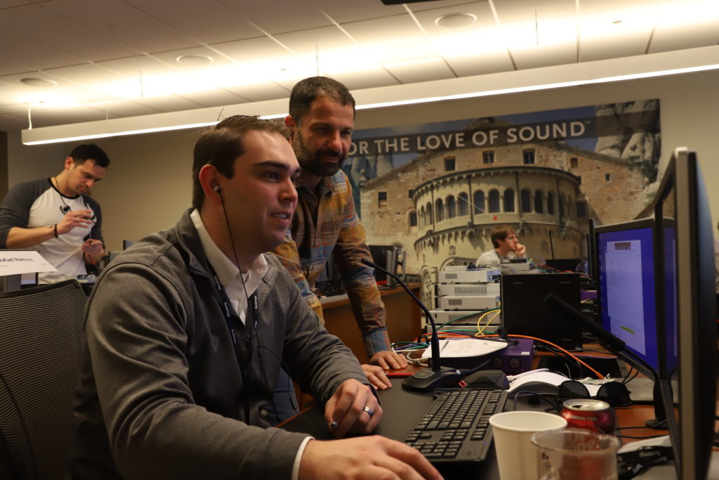 Image of two people looking at a computer screen in an AV lab.
