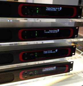 Stacked Biamp TesiraFORTÉ AVB audio DSP rack units with illuminated front panel displays and status LEDs