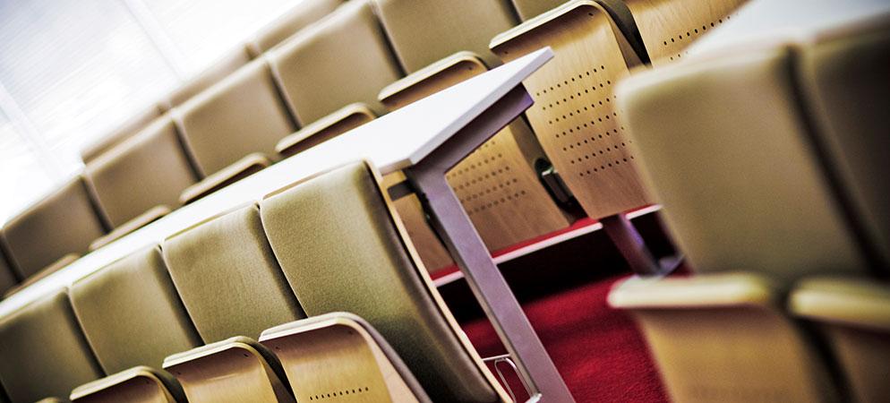 Empty lecture hall seats and desks, university classroom interior for education and training sessions
