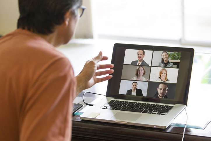 Man joining video conference on laptop with multiple participants, remote work online meeting and virtual team collaboration from home office.