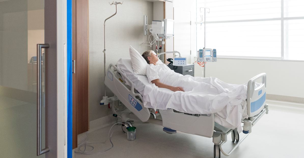Hospital patient resting in modern hospital room bed with medical monitors and IV equipment, inpatient care and recovery setting