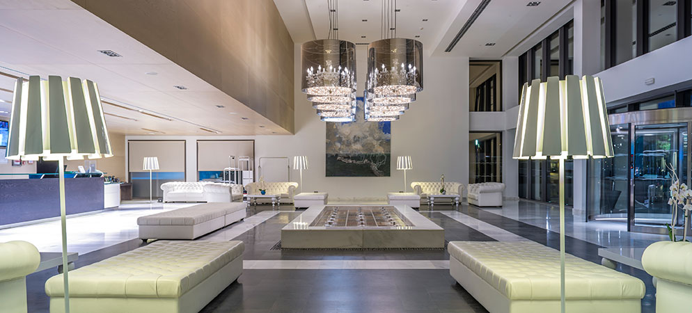 Modern hotel lobby interior with seating, chandeliers, and reception desk, upscale hospitality space design and guest lounge area