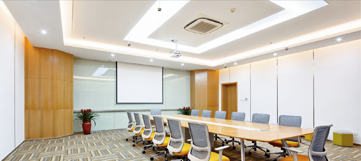 Modern conference room with long meeting table, ergonomic chairs, and ceiling projector screen, ideal for corporate presentations and board meetings