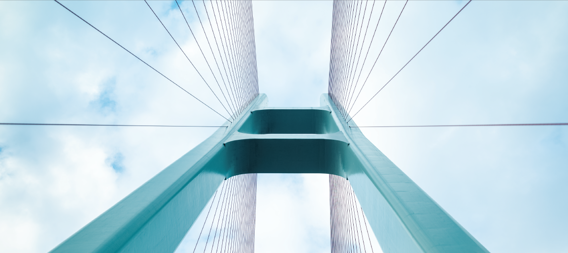 Upward view of cable-stayed bridge tower and suspension cables against blue sky, modern transportation engineering and infrastructure design.