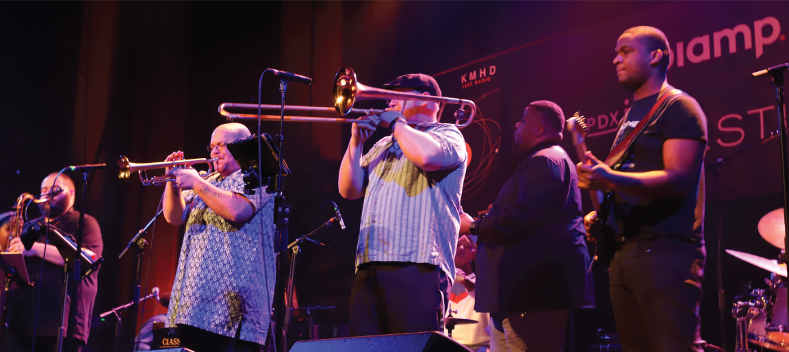 Live jazz band performing on stage with trombone, trumpet and guitar under concert lighting, Biamp-sponsored music event and sound production.