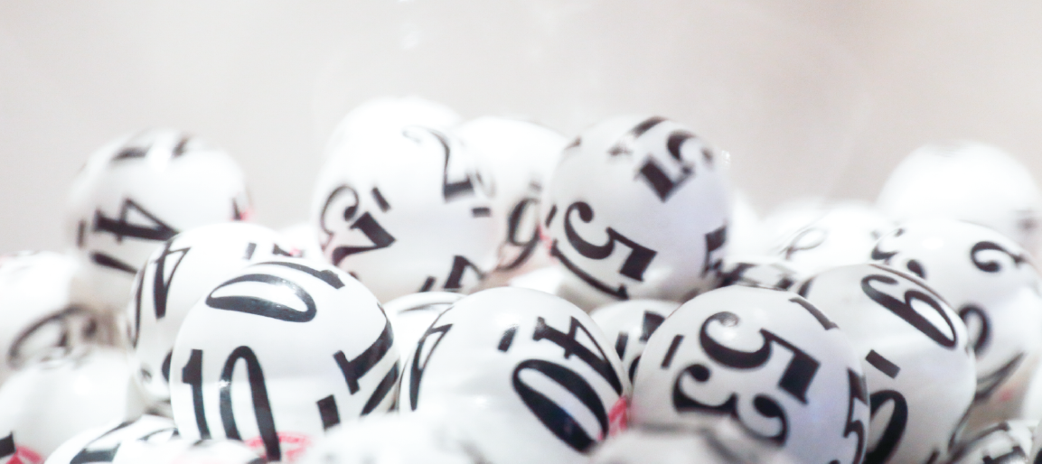 Close-up of white lottery bingo balls with black numbers, game drawing concept and random selection background for raffle or giveaway.