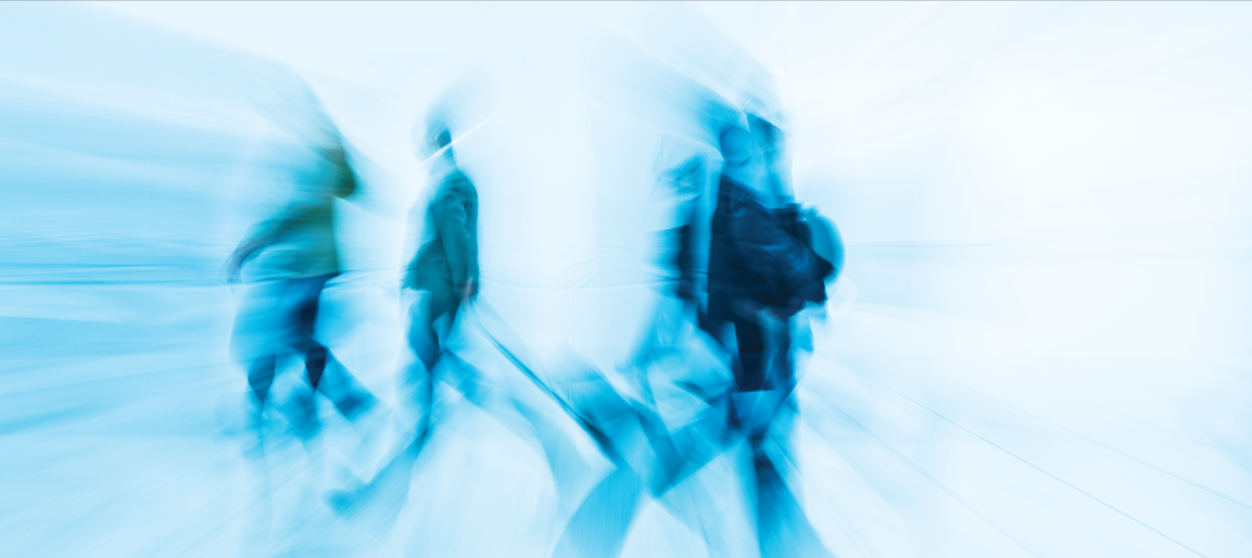 Abstract motion blur of people walking in bright corridor, conveying fast-paced business travel, commuter movement, and urban lifestyle concept