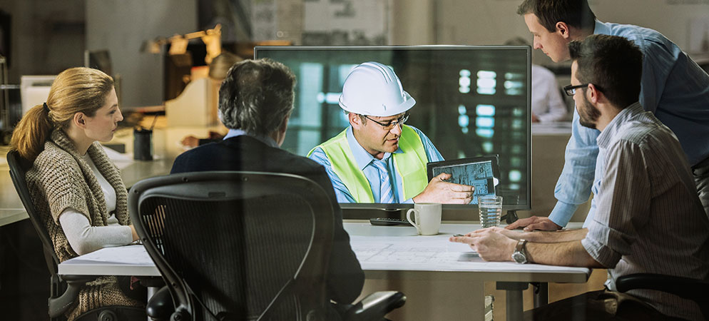 Business team reviewing construction plans in meeting with engineer on video call, remote project collaboration and design discussion in