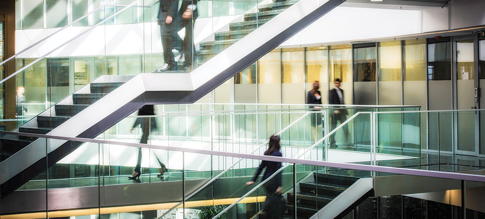Modern office building interior with glass staircases and people walking, corporate workplace architecture and business environment concept