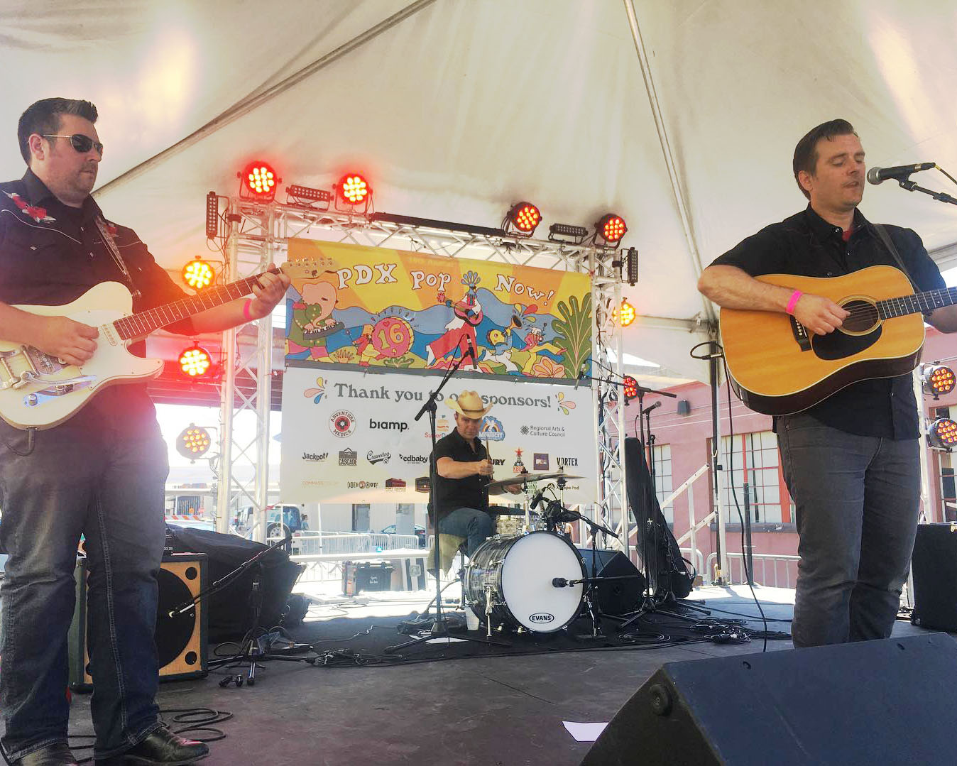 Image of two men playing guitars and performing on a stage with PDX Pop Now!