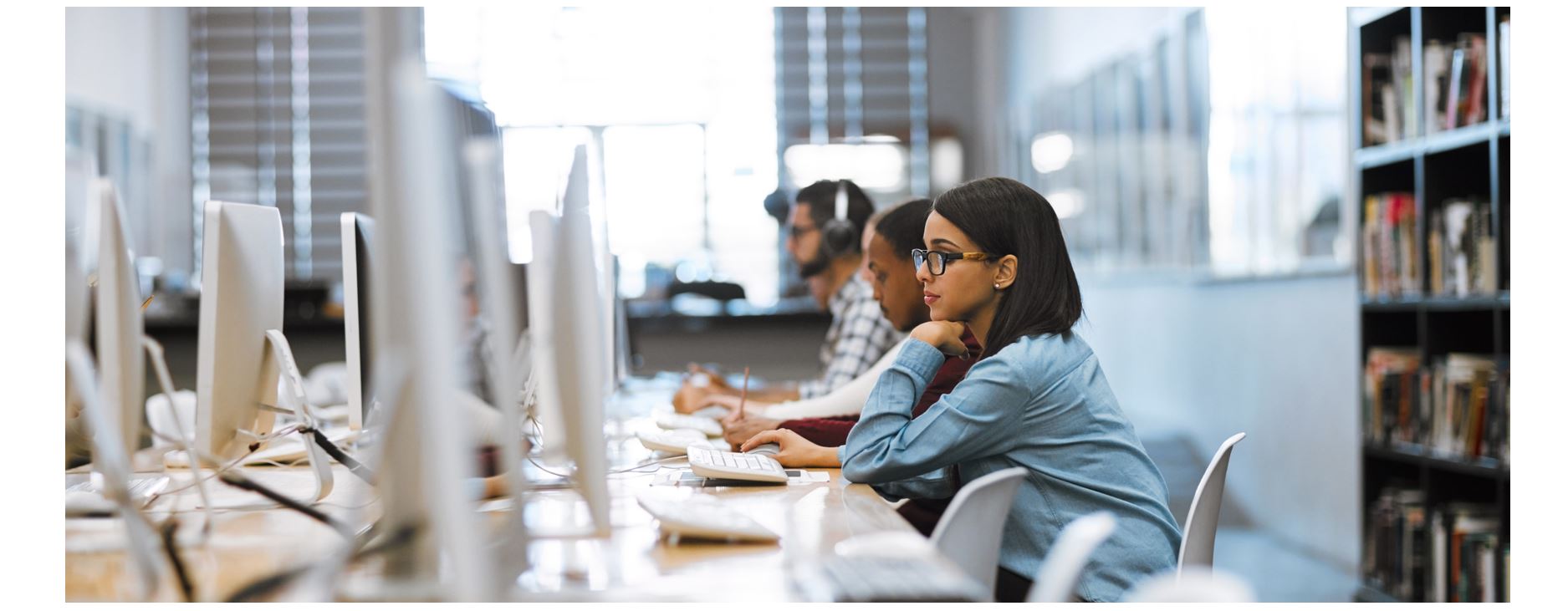 Students working on desktop computers in library computer lab, quiet study environment for research and online learning