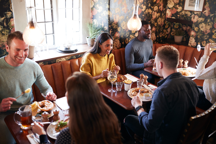 Image of people eating in a restaurant at separate tables.