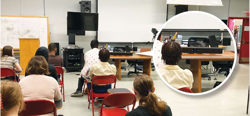 Students seated in classroom facing AV presentation setup with camera and soundbar, training room technology for hybrid learning and lectures