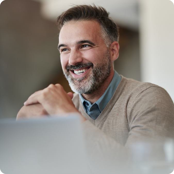 Man smiling sitting in front of a laptop