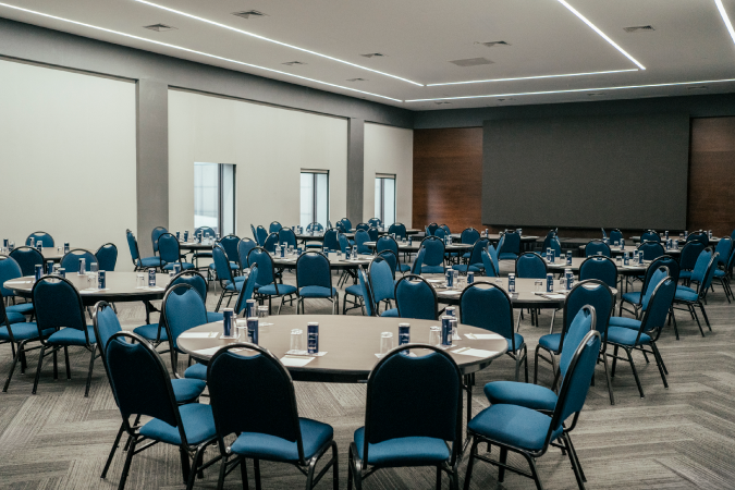 banquet room with tables and chairs facing projector screen