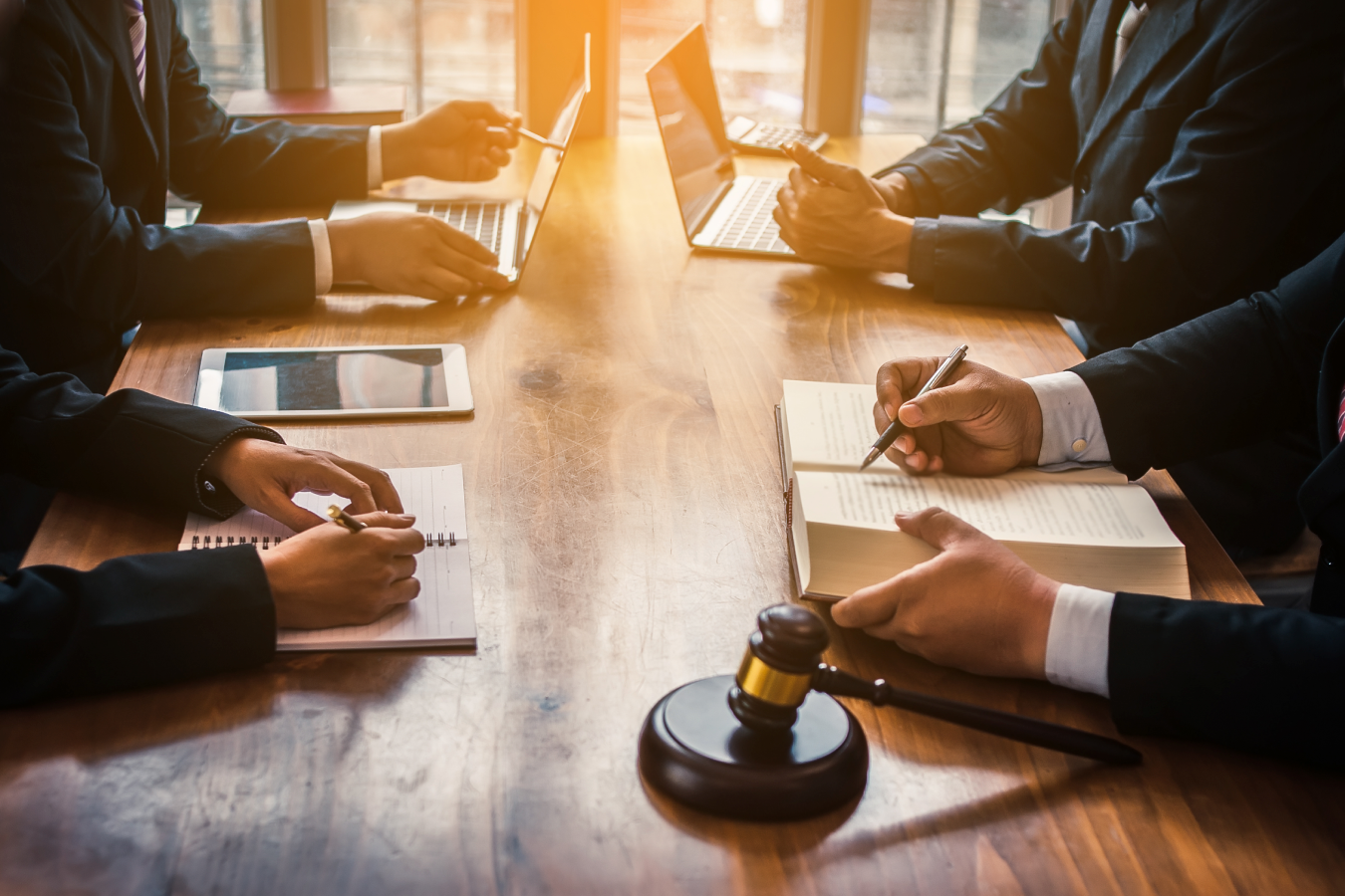 People at a conference table with a gavel in the foreground
