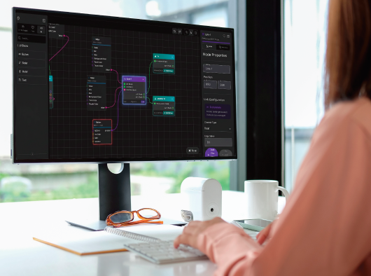 Person using workplace control software on desktop monitor with node-based automation workflow and device configuration interface