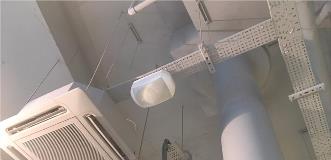Industrial interior ceiling with exposed HVAC ducts, metal beams, and suspended equipment.