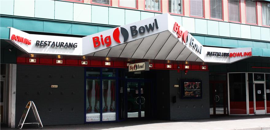 Entrance to “Big Bowl” bowling center and restaurant with large marquee signage over glass doors.