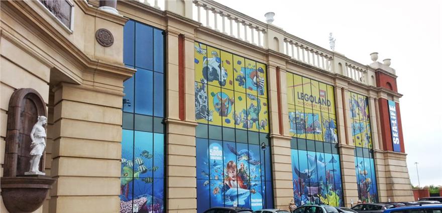 Exterior of a Legoland Sea Life building decorated with large colorful underwater-themed murals.