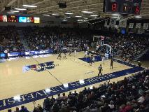 Crowded indoor arena where fans watch a college basketball game on a court marked “Washburn University.”