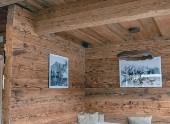 Cozy rustic wooden room interior with wall art and ceiling speaker blending into timber décor