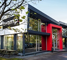 Biamp modern office building exterior with red entrance and large glass windows