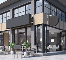Modern glass-front café or restaurant with outdoor seating and blank signage