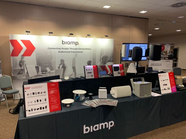 Biamp trade show booth displaying professional audiovisual equipment and speakers on exhibit tables.