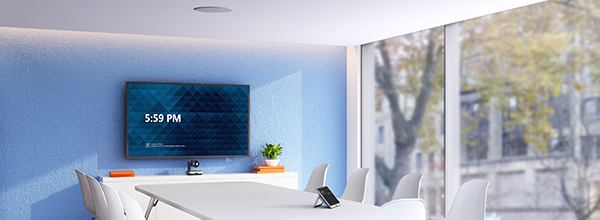 Bright modern conference room with display, PTZ camera, and touch controller, illustrating a clean AV‑equipped meeting space.