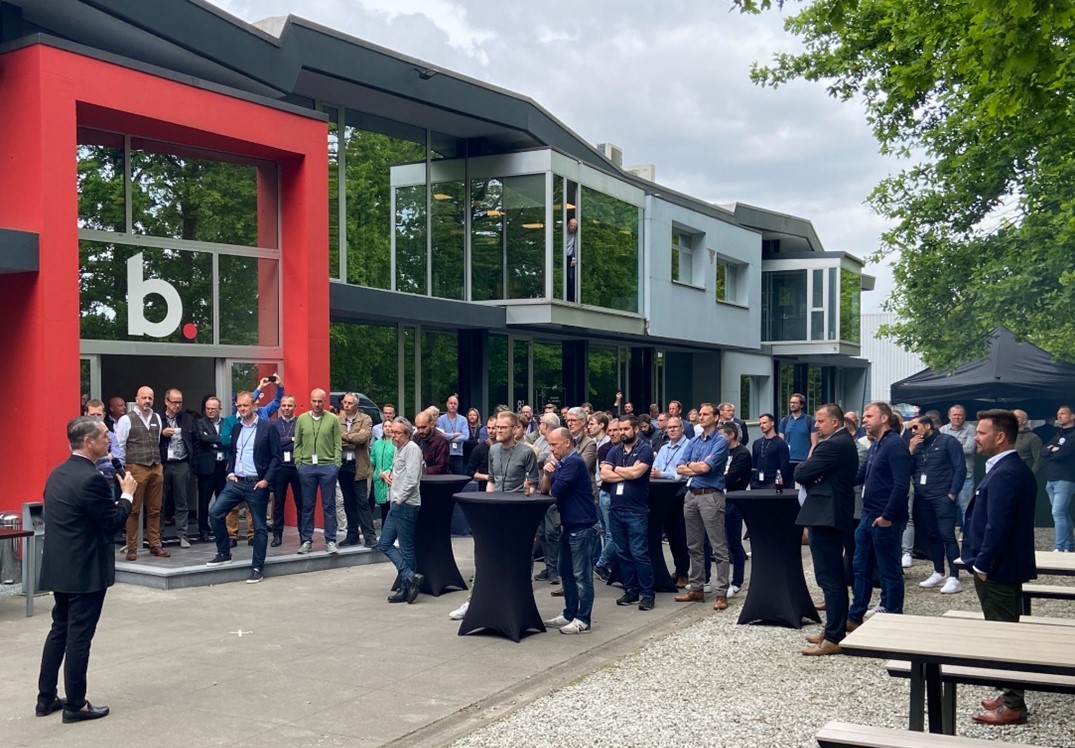 Outdoor event at Biamp facility with large group listening to a speaker, showcasing partner networking and corporate community gathering.