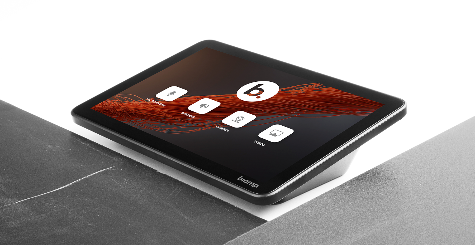 Biamp touch control panel on conference table displaying intuitive icons to manage microphone, speakers, camera, and video in meeting rooms.
