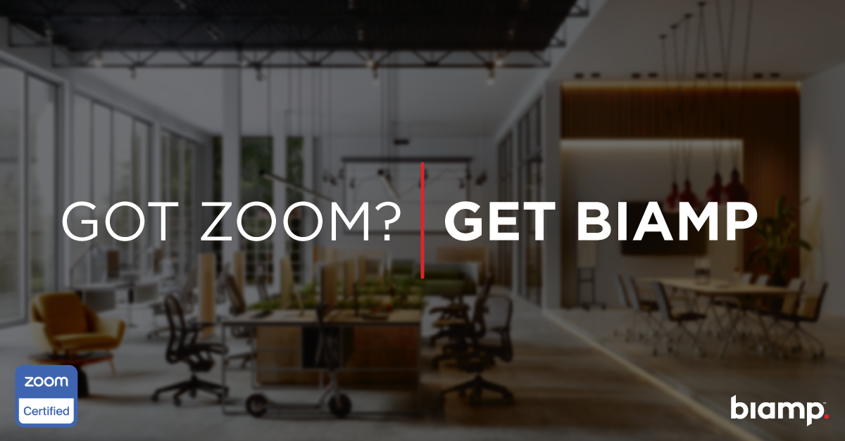 Modern hybrid office with open workstations and meeting area overlaid with slogan “Got Zoom? Get Biamp” and Zoom Certified badge.