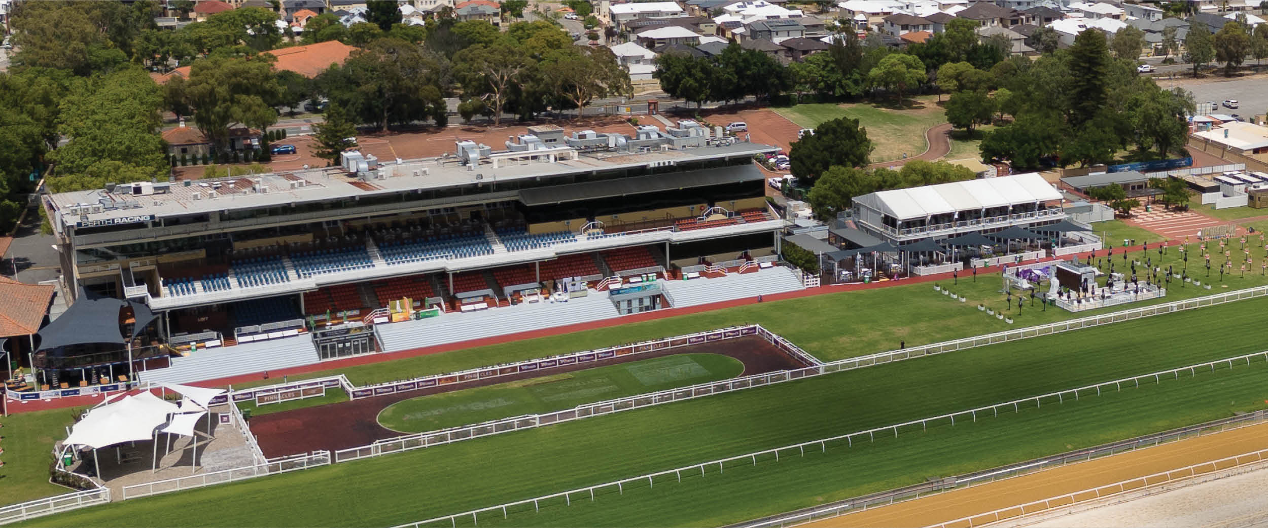 Aerial view of Perth Racing horse racetrack and grandstand complex, showcasing outdoor sports venue, spectator seating, and lush infield.