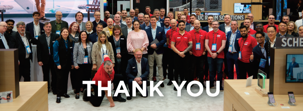 Biamp trade show group photo with staff and partners standing in booth, overlaid with bold “Thank You” message to event visitors.