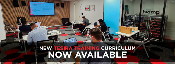 Training room with attendees at laptops and a screen at the front, overlaid text: “New Tesira Training Curriculum Now Available.”