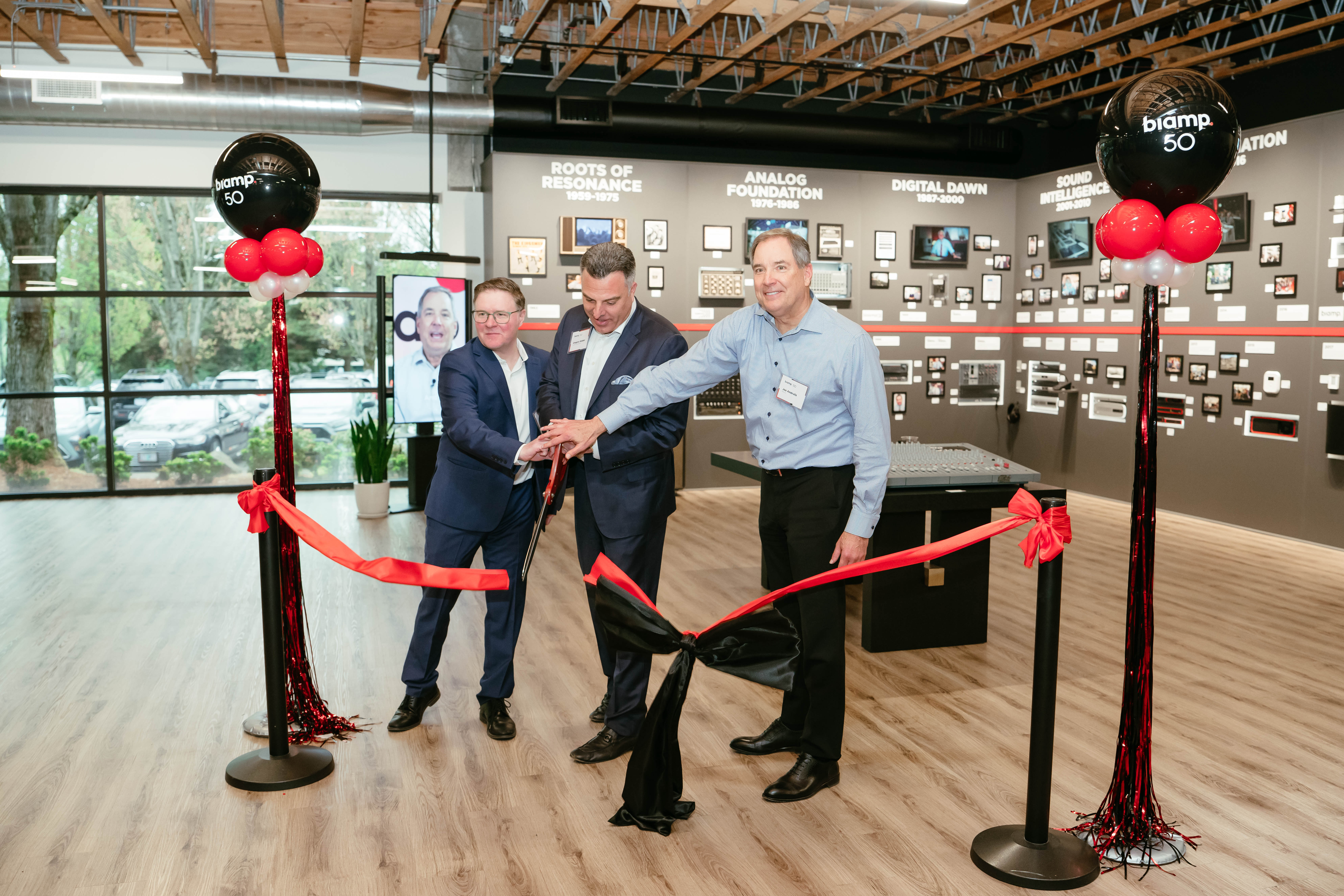 Biamp 50th anniversary ribbon-cutting ceremony with executives celebrating inside company history exhibit space