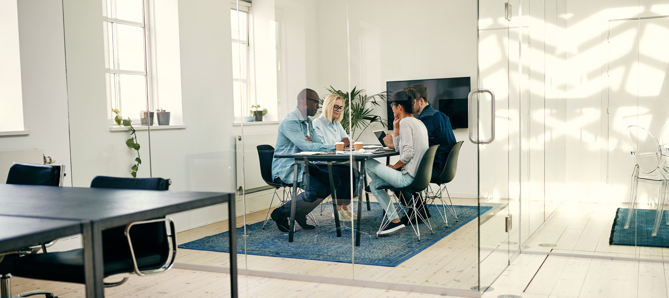 Four people in a meeting room