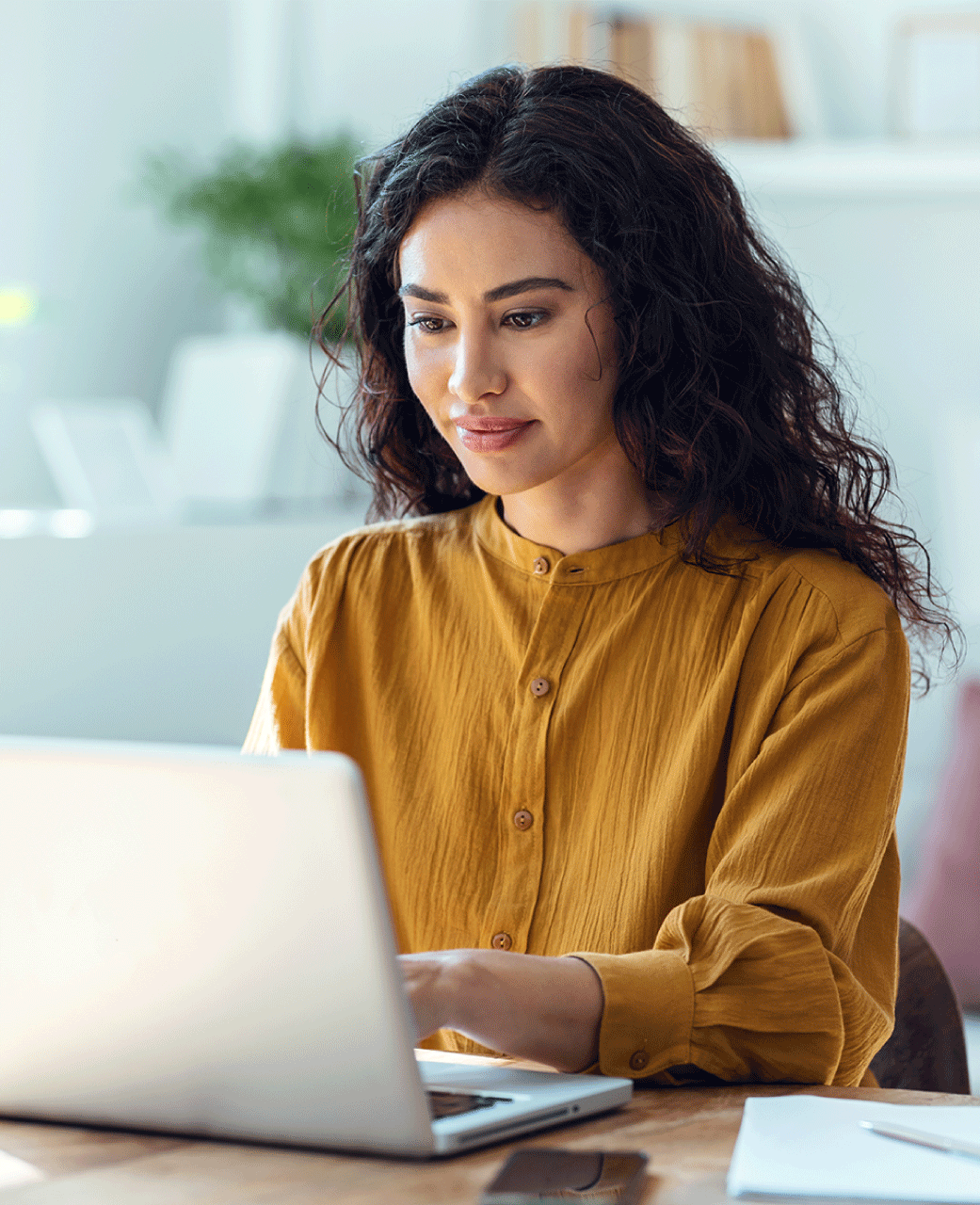 Woman with long hair at a desk on a laptop